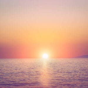 A sunset over the ocean with no one in it.