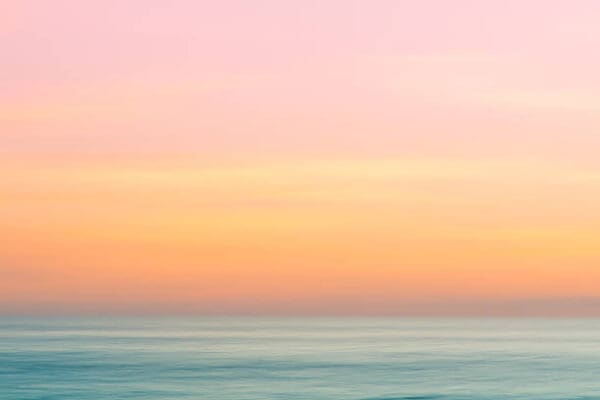 A pink and yellow sky over the ocean